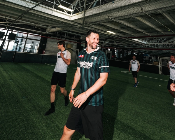 Des joueurs en tenue sportive sur un terrain de soccer intérieur à l'installation d'entraînement Unlimited Soccer avec gazon