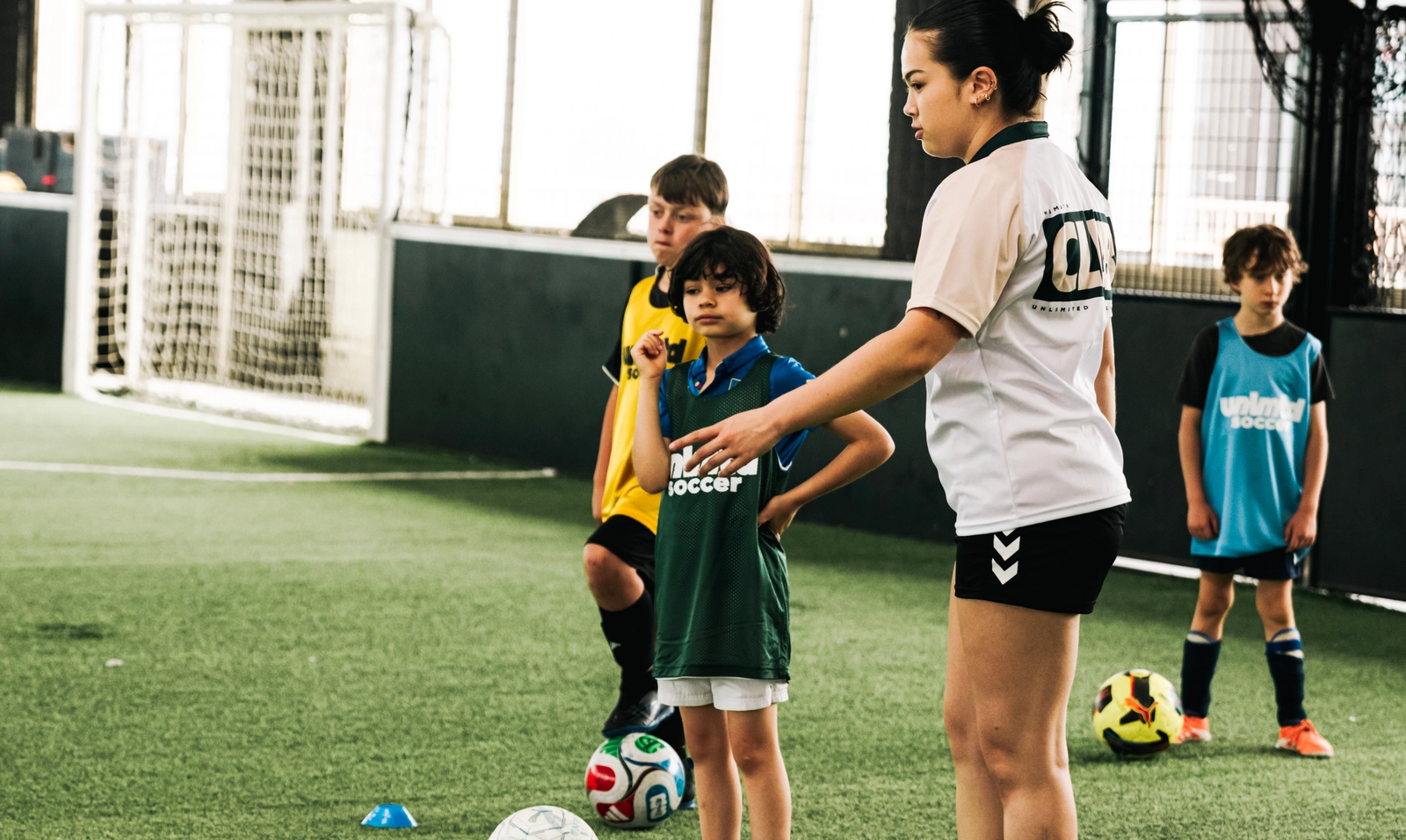 Un entraîneur de soccer pour jeunes donnant des instructions à des joueurs juniors lors d'une séance d'entraînement sur un